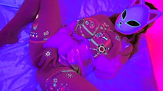 Lilykoti, the neon-glowing masked hottie with massive tits, masturbates wildly with anime moans.